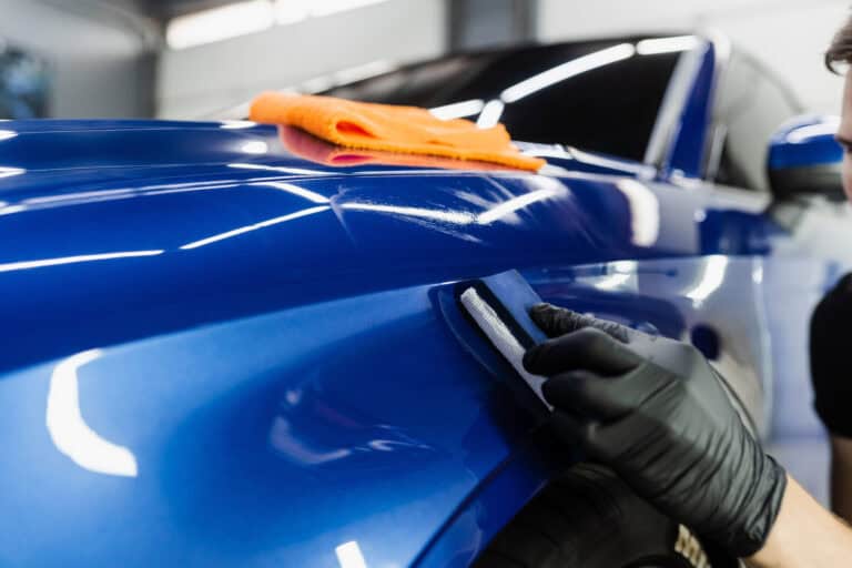 Polishing car paint on a blue BMW after it finished a complete collision repair.