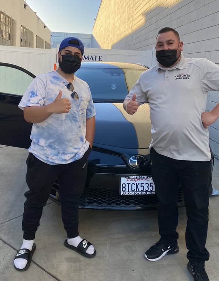 Customer standing with certified technician in front of a Toyota Corolla after a Toyota Collision Repair.